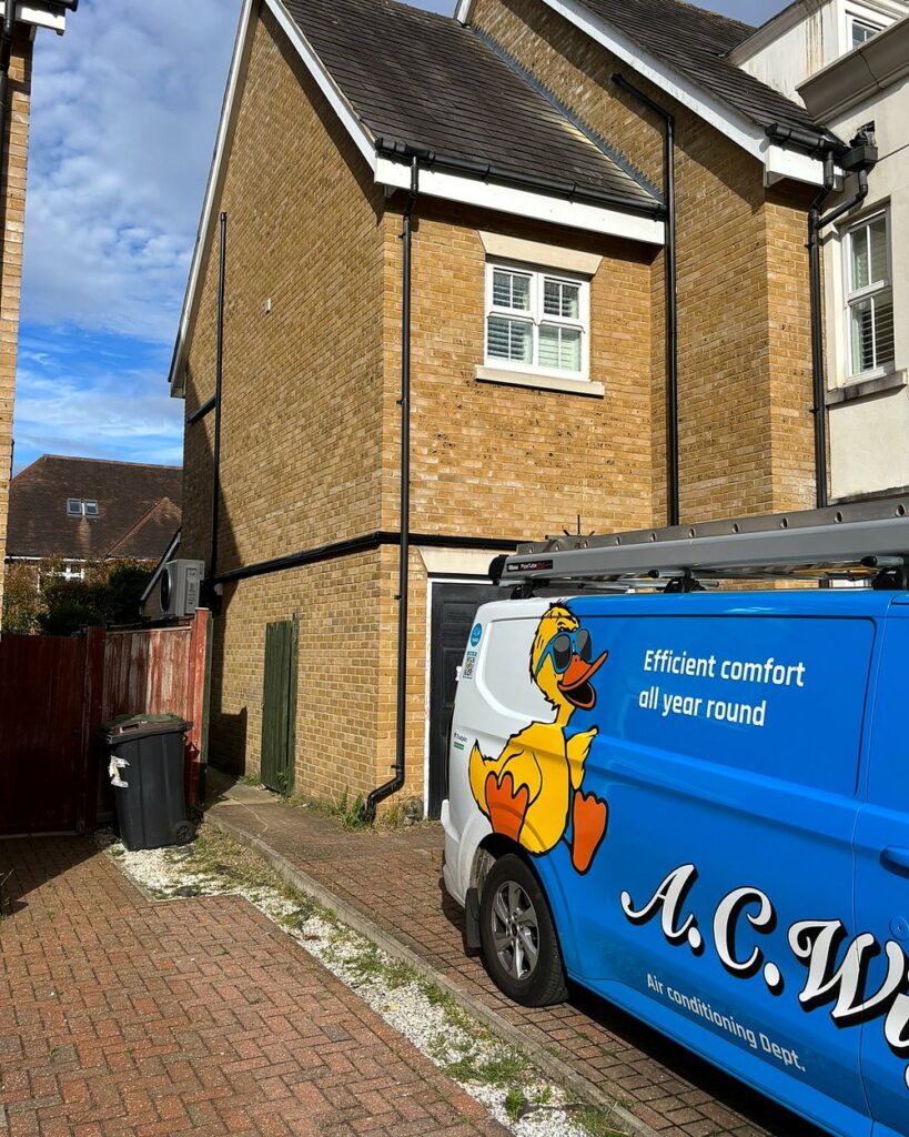 A.C. Wilgar air conditioning van outside a home with a newly installed outdoor unit
